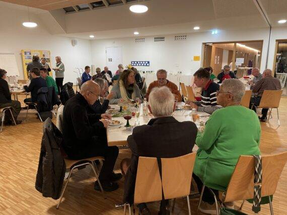 Quelle: Friedensgemeinde Baden-Baden Bild: Ehrenamtliche an Tischen beim Mitarbeiterdank im Annelise-Fehrholz-Saal.